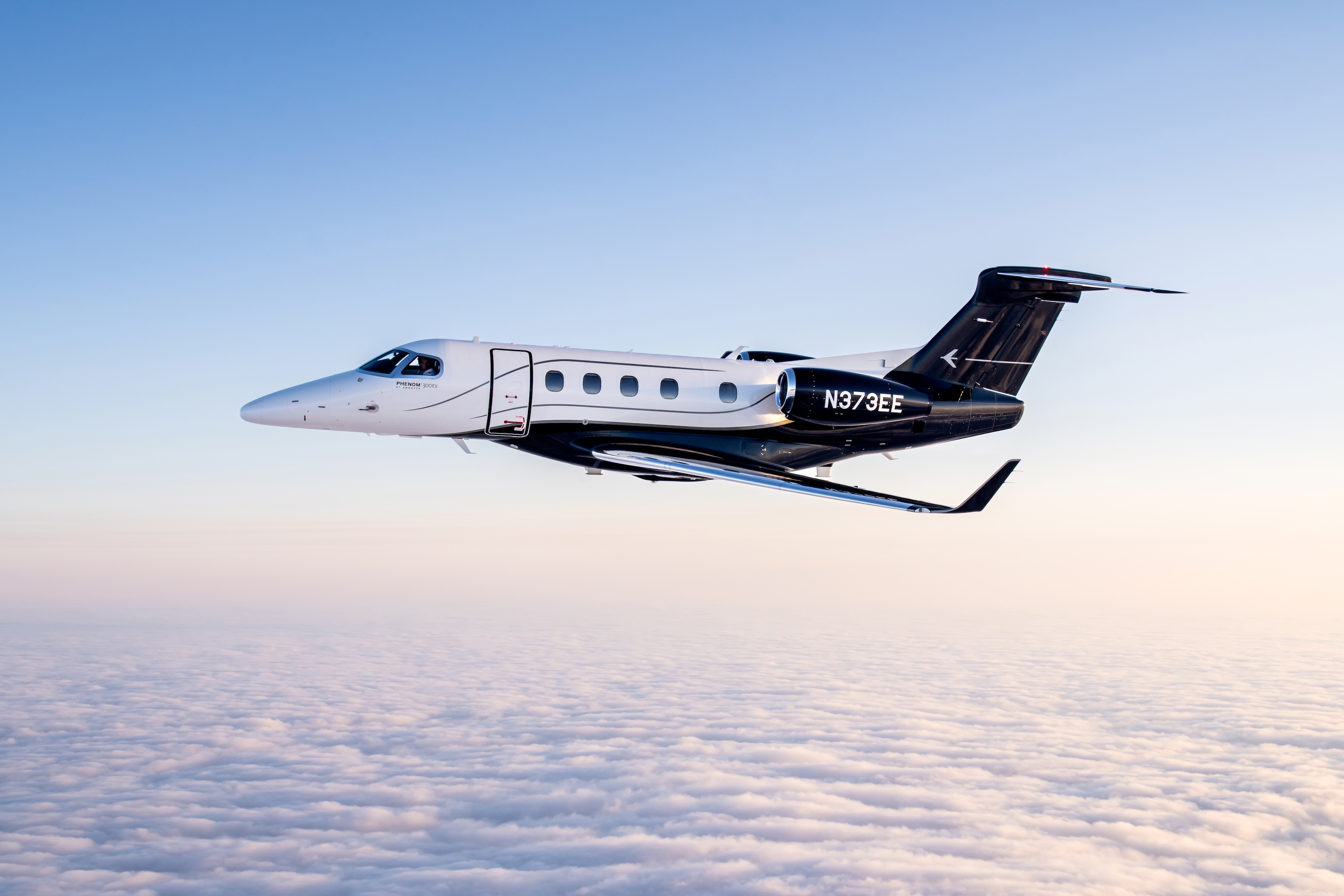 Embraer Phenom 300 flying above clouds